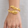 Gold-tone clownfish bangle with raised fish and wave details