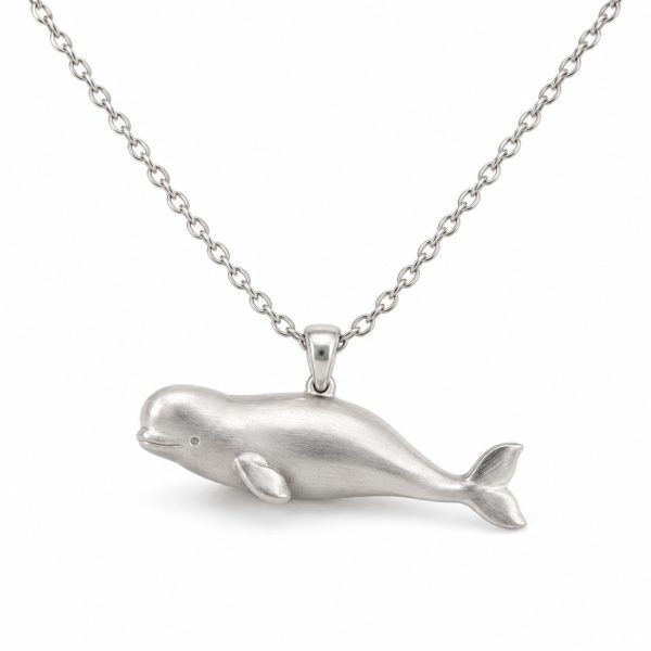 Silver-tone beluga whale pendant necklace with a rounded forehead, textured body and oval-link chain on a white background