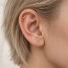 Miniature gold-tone hammerhead shark stud worn inside the upper ear