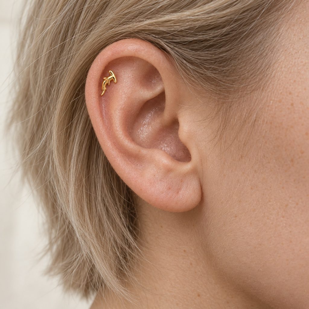 Miniature gold-tone hammerhead shark stud worn inside the upper ear