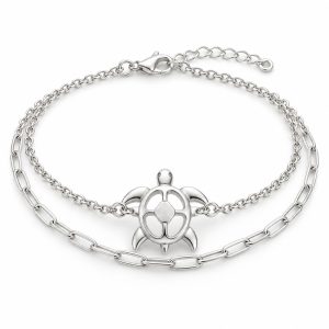 Silver-tone openwork sea turtle bracelet with cable and paperclip-style chains, lobster clasp and extension chain on white