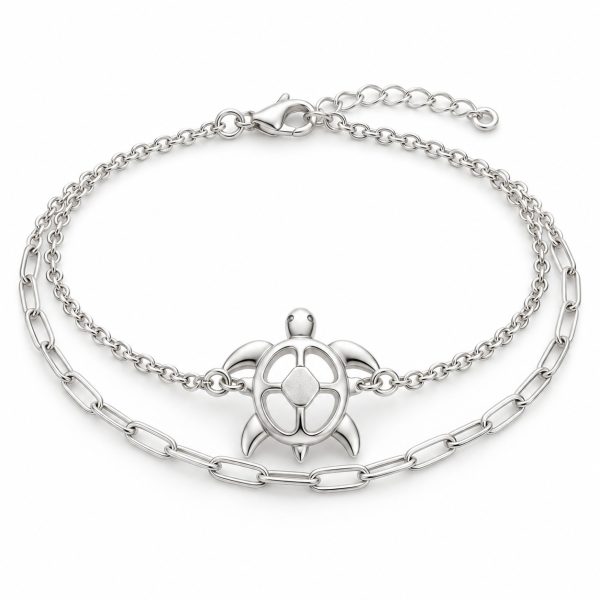 Silver-tone openwork sea turtle bracelet with cable and paperclip-style chains, lobster clasp and extension chain on white