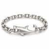 Silver-tone shark bracelet with a hollow eye, mouth holding a chain link and curved tail hook on a white background
