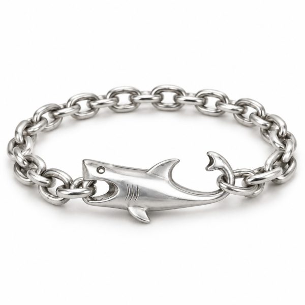Silver-tone shark bracelet with a hollow eye, mouth holding a chain link and curved tail hook on a white background