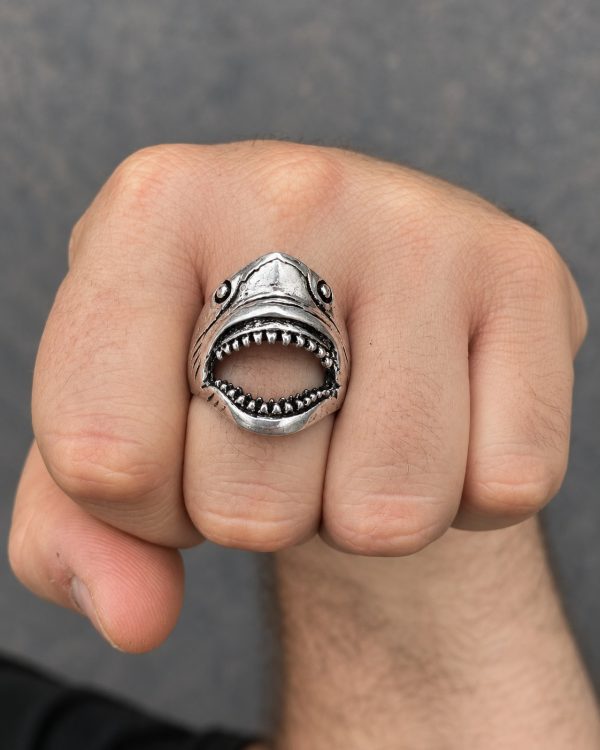 Silver-tone open mouth shark ring worn on a finger, showing its sculpted head, teeth and cutout mouth