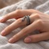Silver-tone coiled snake ring worn on a finger, showing the layered body, head and textured scales
